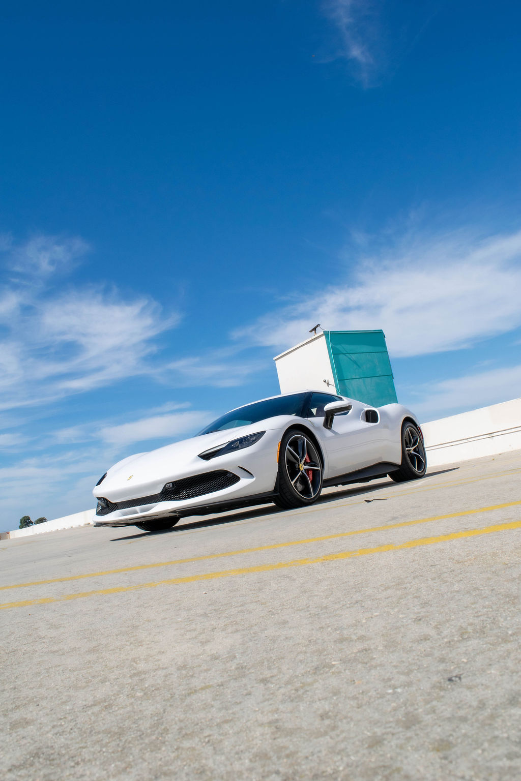 Ferrari 296 GTB rental, an 819 hp plug-in hybrid V6 supercar in white