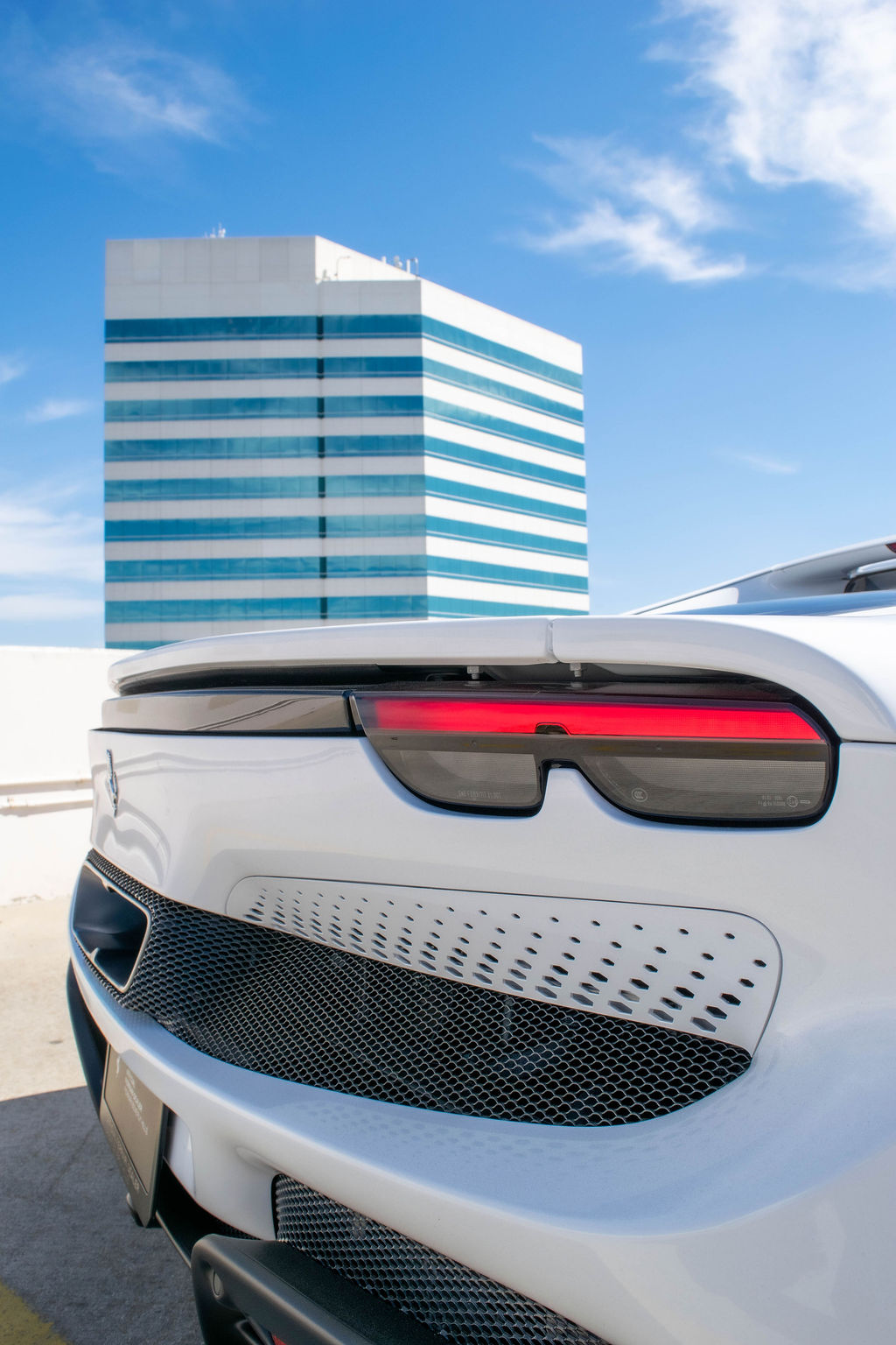 White Ferrari 296 GTB rental, a mid-engined rear-wheel drive supercar