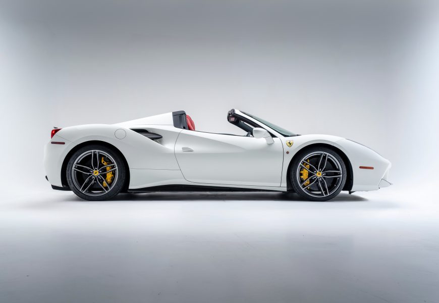 Side view of the Ferrari 488 Spider rental in white, a 2 seat folding hardtop convertible