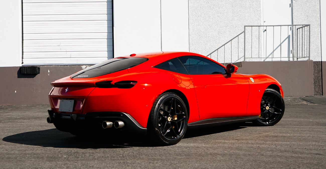 Rear view of the red Ferrari Roma rental, a front-engined V8 coupe
