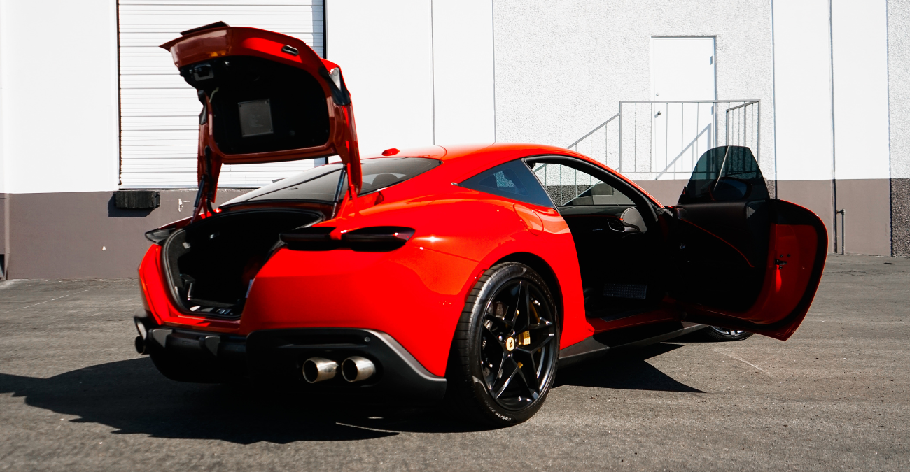 Rear view of the red Ferrari Roma rental with the doors open