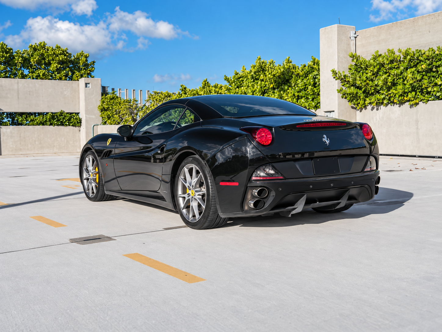Rear view of the black Ferrari California T rental, a 196 mph convertible