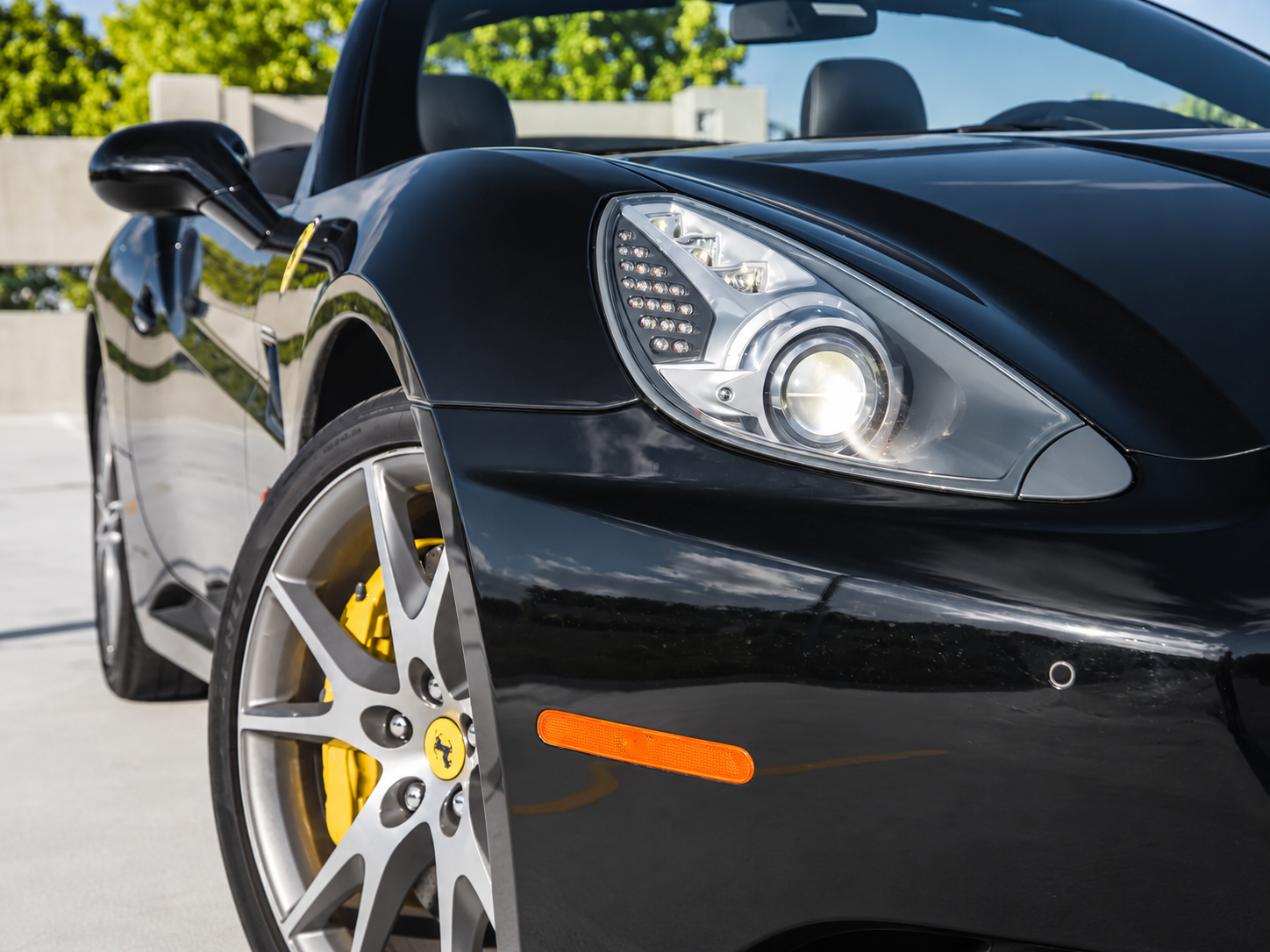 Headlight on the black Ferrari California T rental, a 553 hp V8 convertible