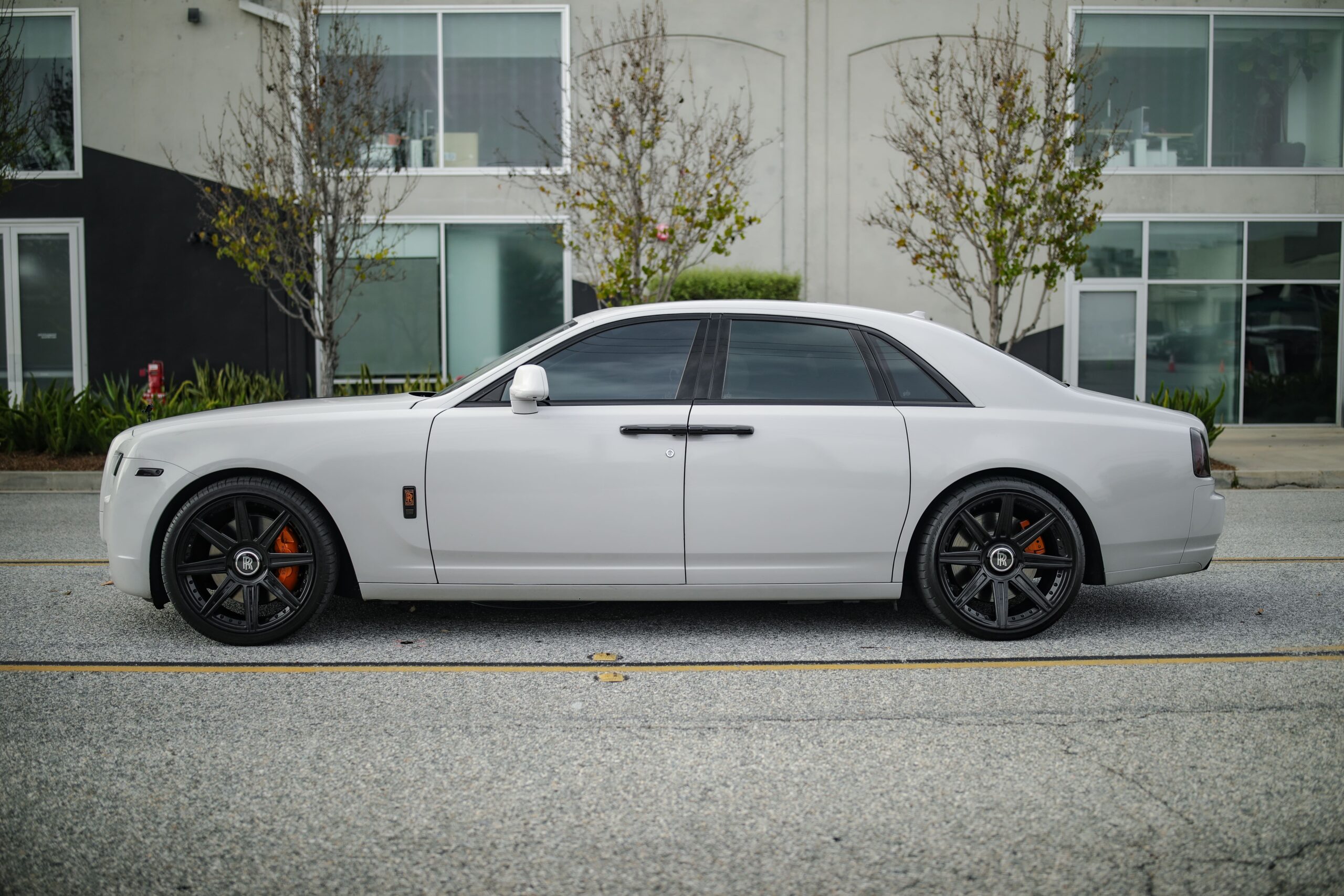 Side view of the white Rolls Royce Ghost rental, a 155 mph luxury sedan