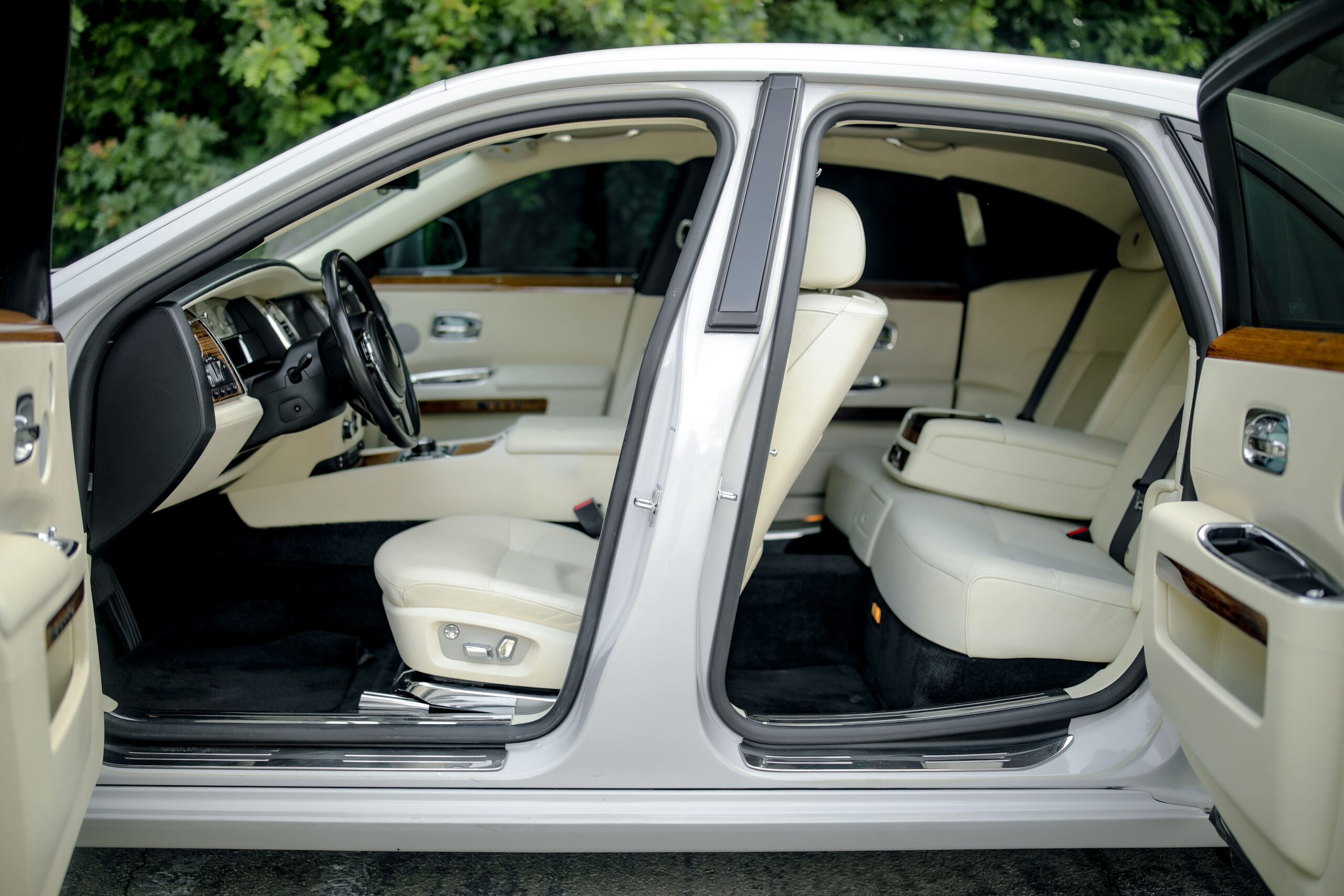 Doors open on the white Rolls Royce Ghost rental, a 563 hp twin-turbo V12