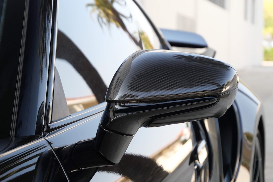 Mirror on the black Porsche 911 Turbo S rental, a twin-turbo flat-six coupe
