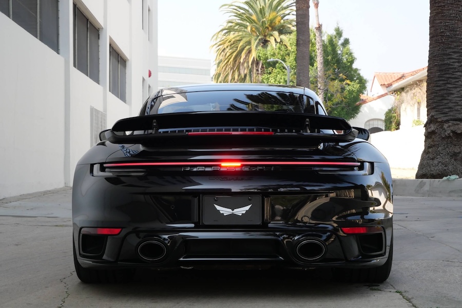 Rear view of the Porsche 911 Turbo rental in black, a 205 mph coupe