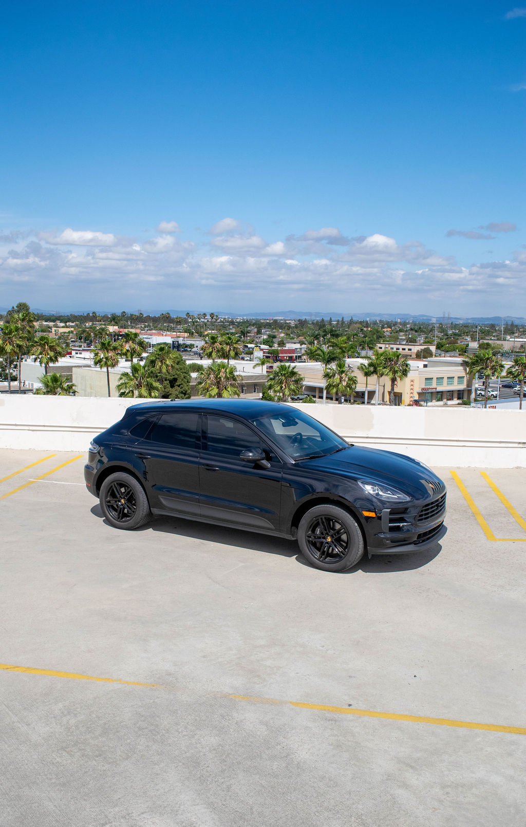 Black Porsche Macan rental, a compact SUV with a center analogue tachometer