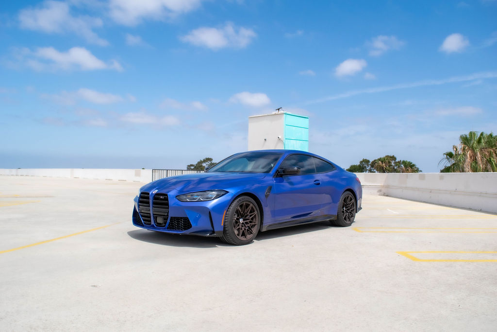 BMW M4 rental in blue, a coupe sharing its engine and chassis with the M3