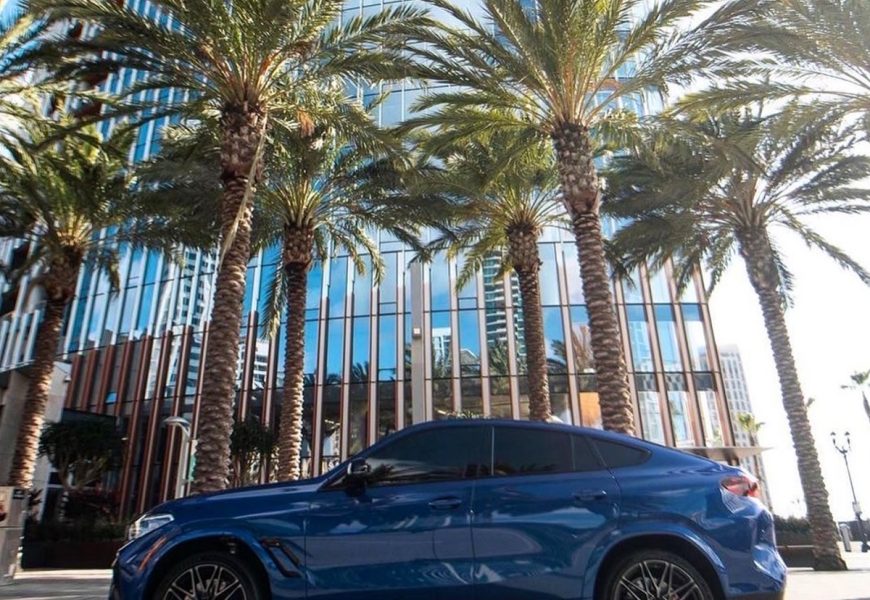Side view of the blue BMW X6 M rental, an SUV with a coupe roofline