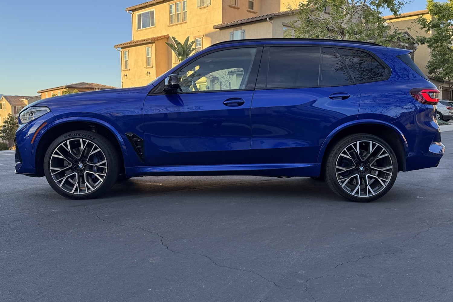 Side view of the blue BMW X5 M Competition rental, a 4 door performance SUV