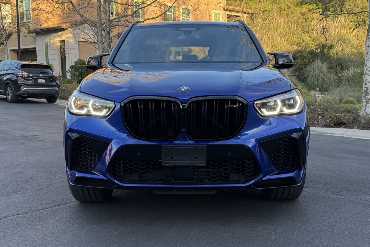 Front view of the blue BMW X5 M rental, an all-wheel drive luxury SUV