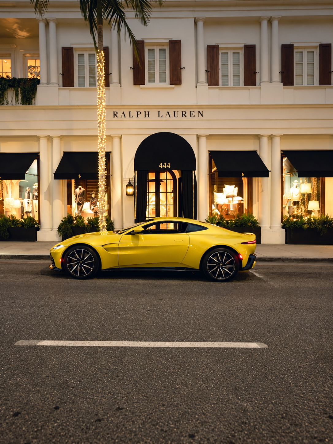 Side view of the yellow Aston Martin Vantage rental, a 2 door coupe