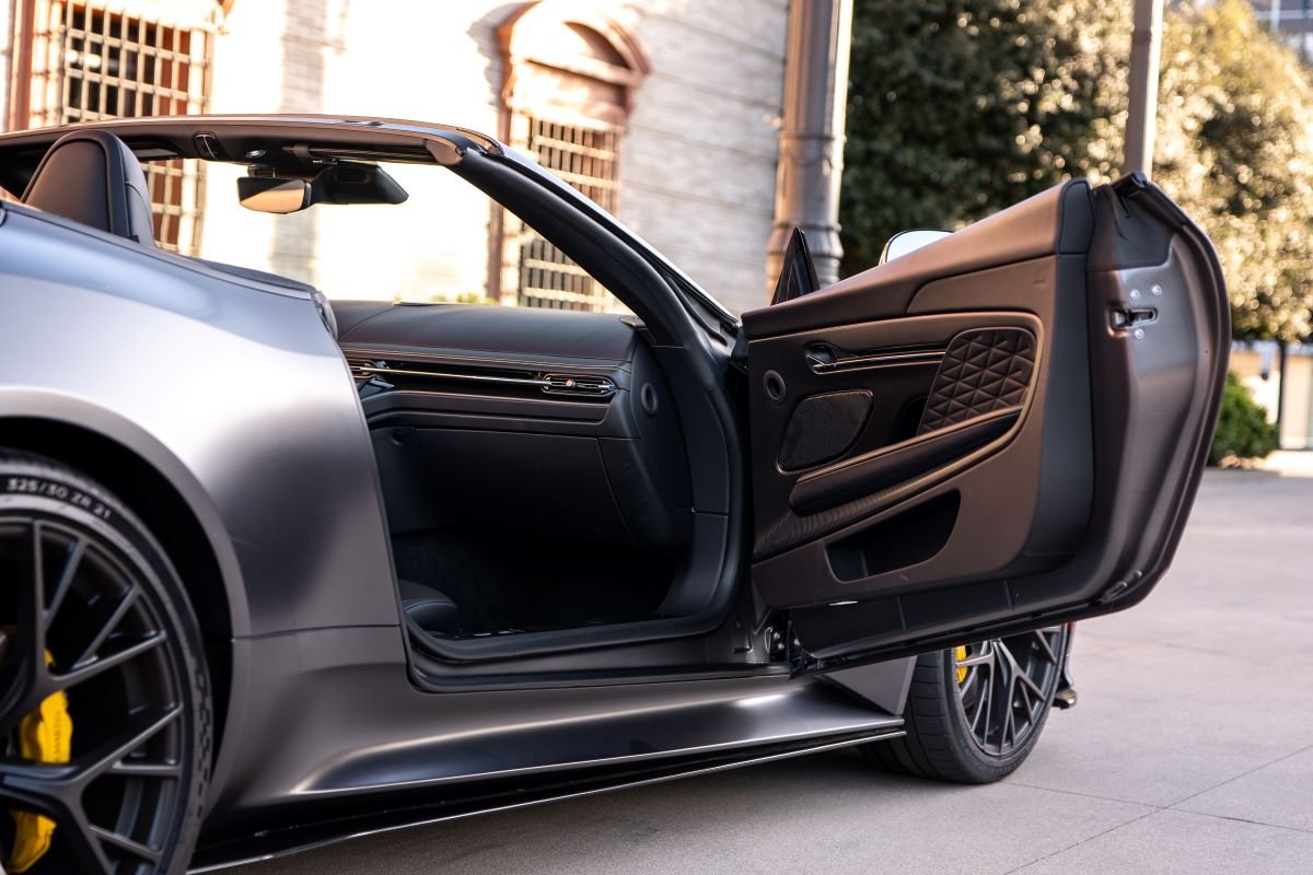 Grey Aston Martin DB12 Volante with a door open, Black interior