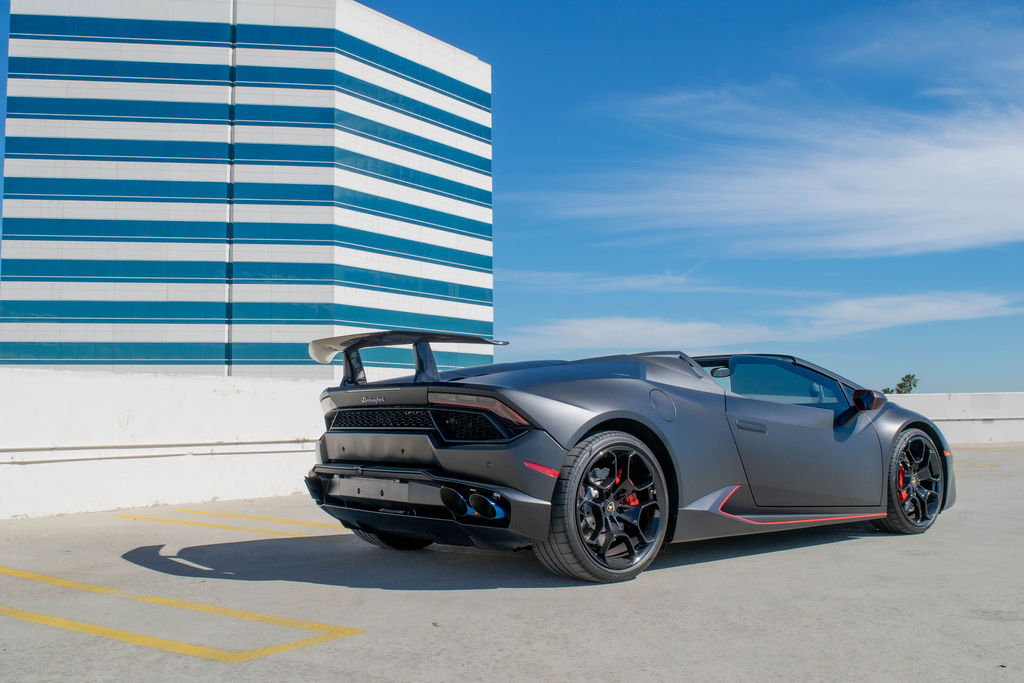 Black Lamborghini Huracan Spyder with the roof down and its red cabin showing, the best convertible to rent