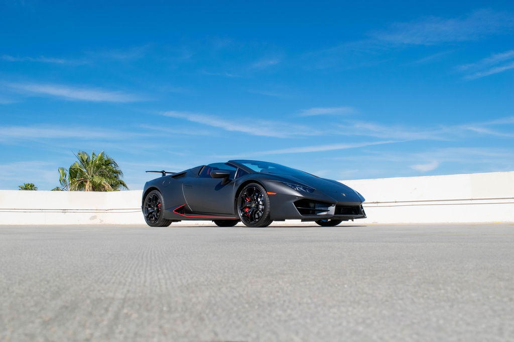 Black Lamborghini Huracan Spyder supercar rental in Orange County with Red interior