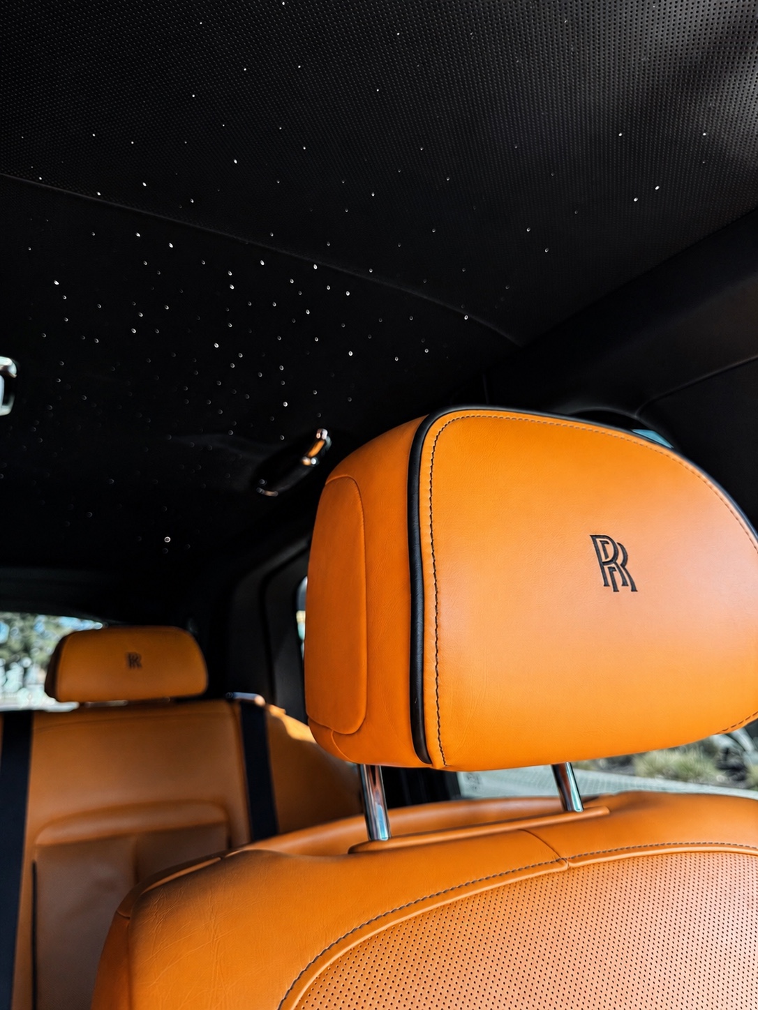 Black Rolls Royce Cullinan Black Badge over orange, front three quarter view, the $1,595 a day car priced in this Cullinan rental cost guide