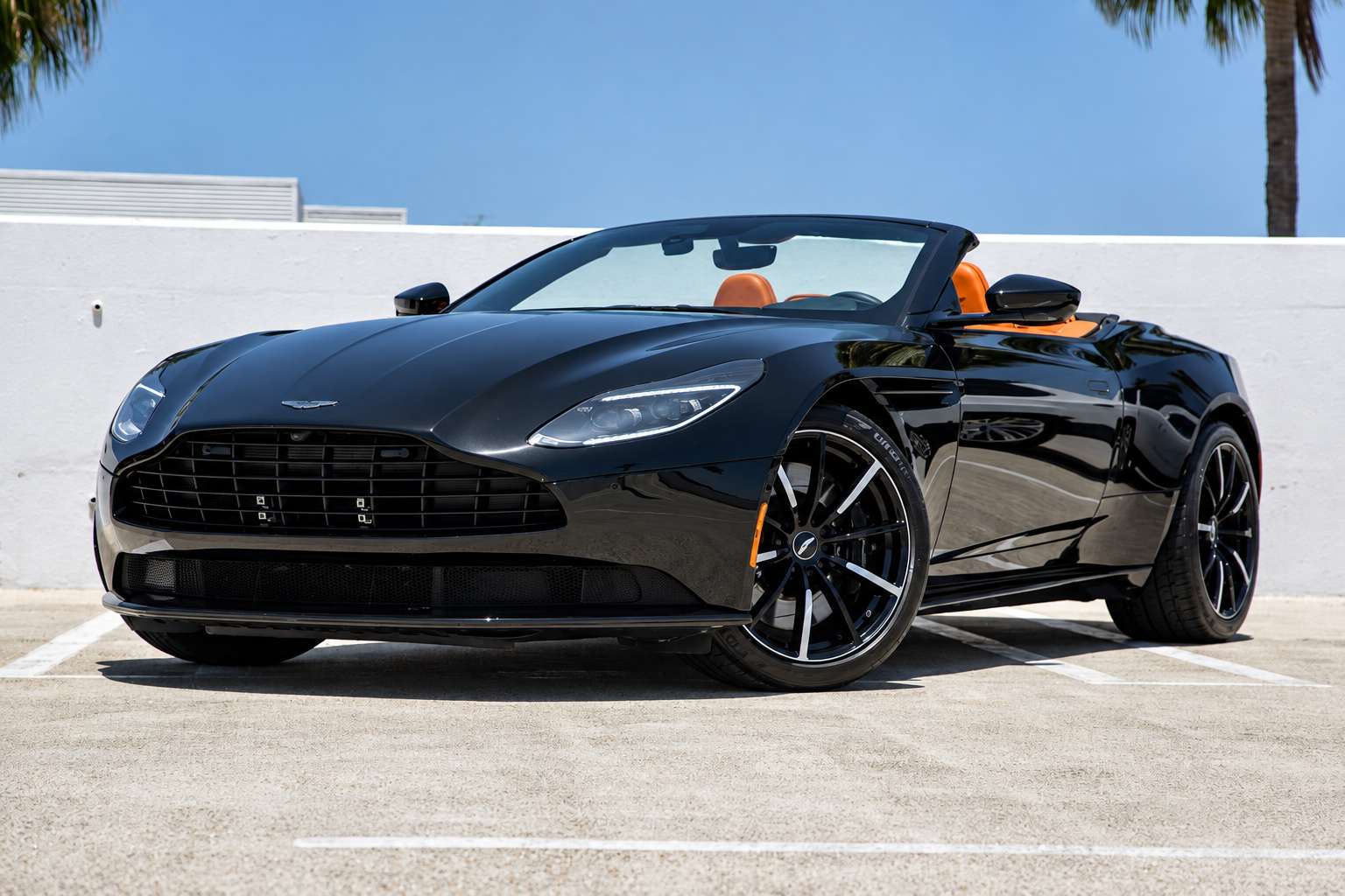 Low front three-quarter of the black Aston Martin DB11 Volante with the roof down under a clear sky