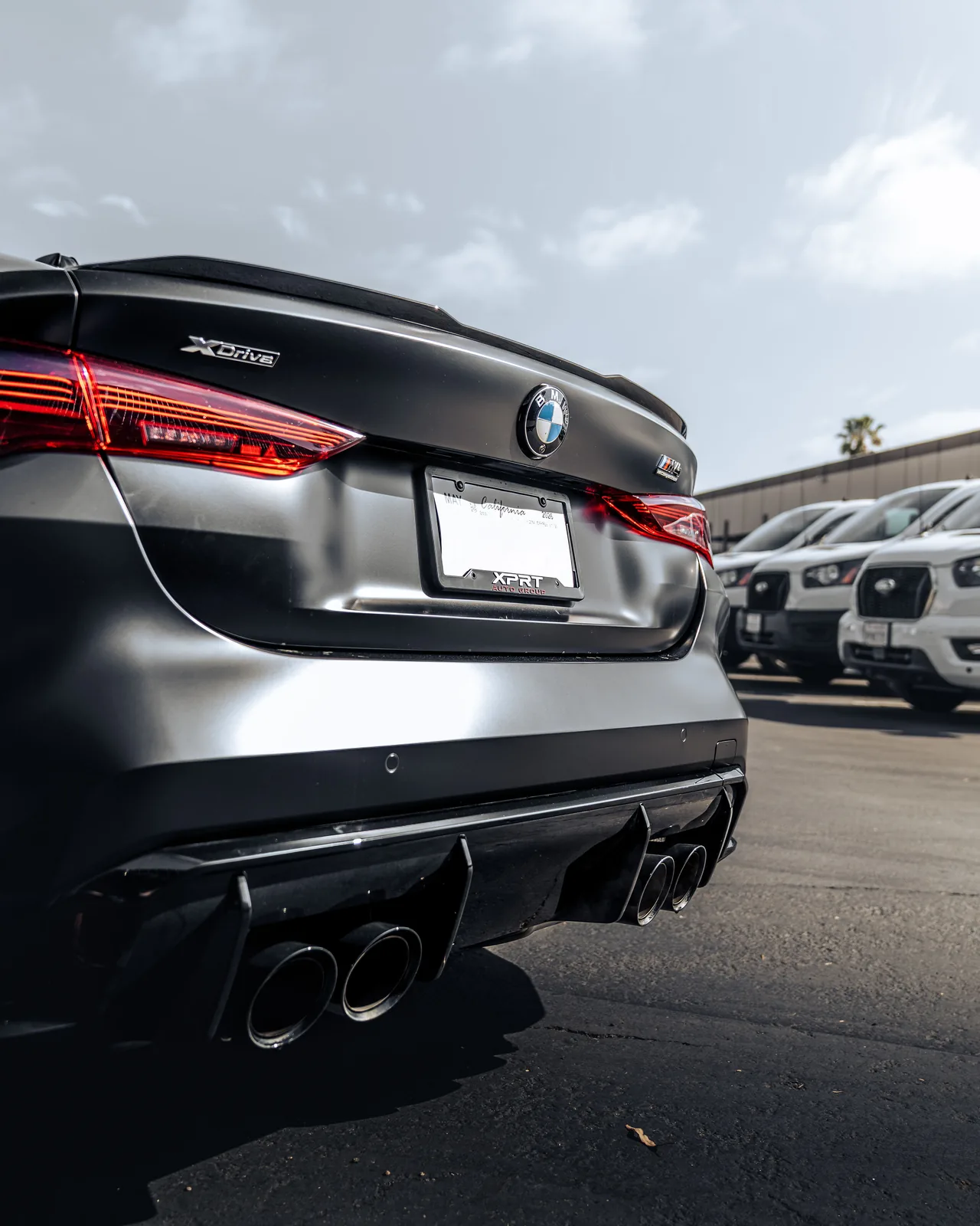 Low rear view of the satin black M4 Competition, quad tailpipes and the black rear diffuser