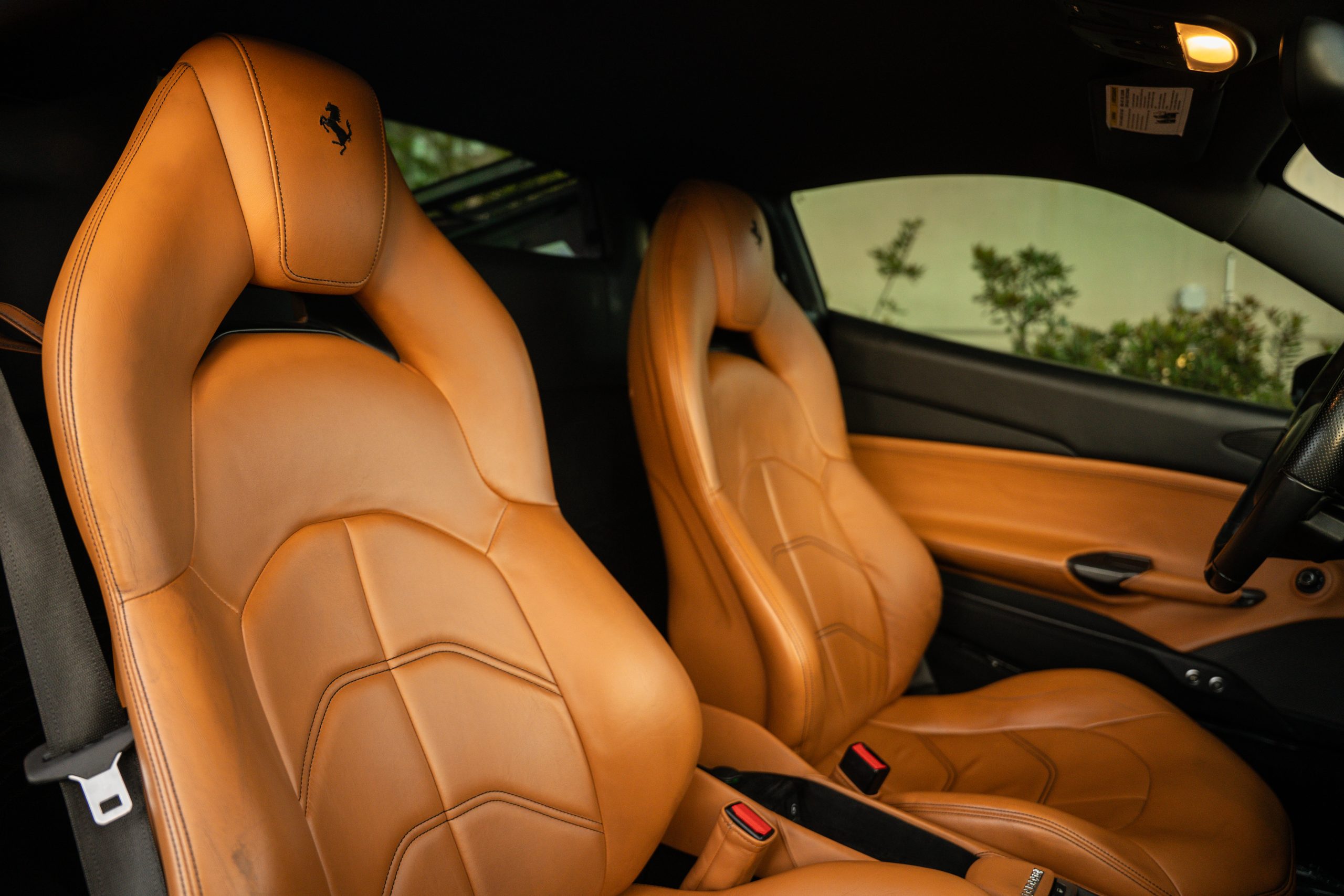 Tan cuoio leather seats of the Ferrari 488 GTB with the prancing horse stitched into the headrests