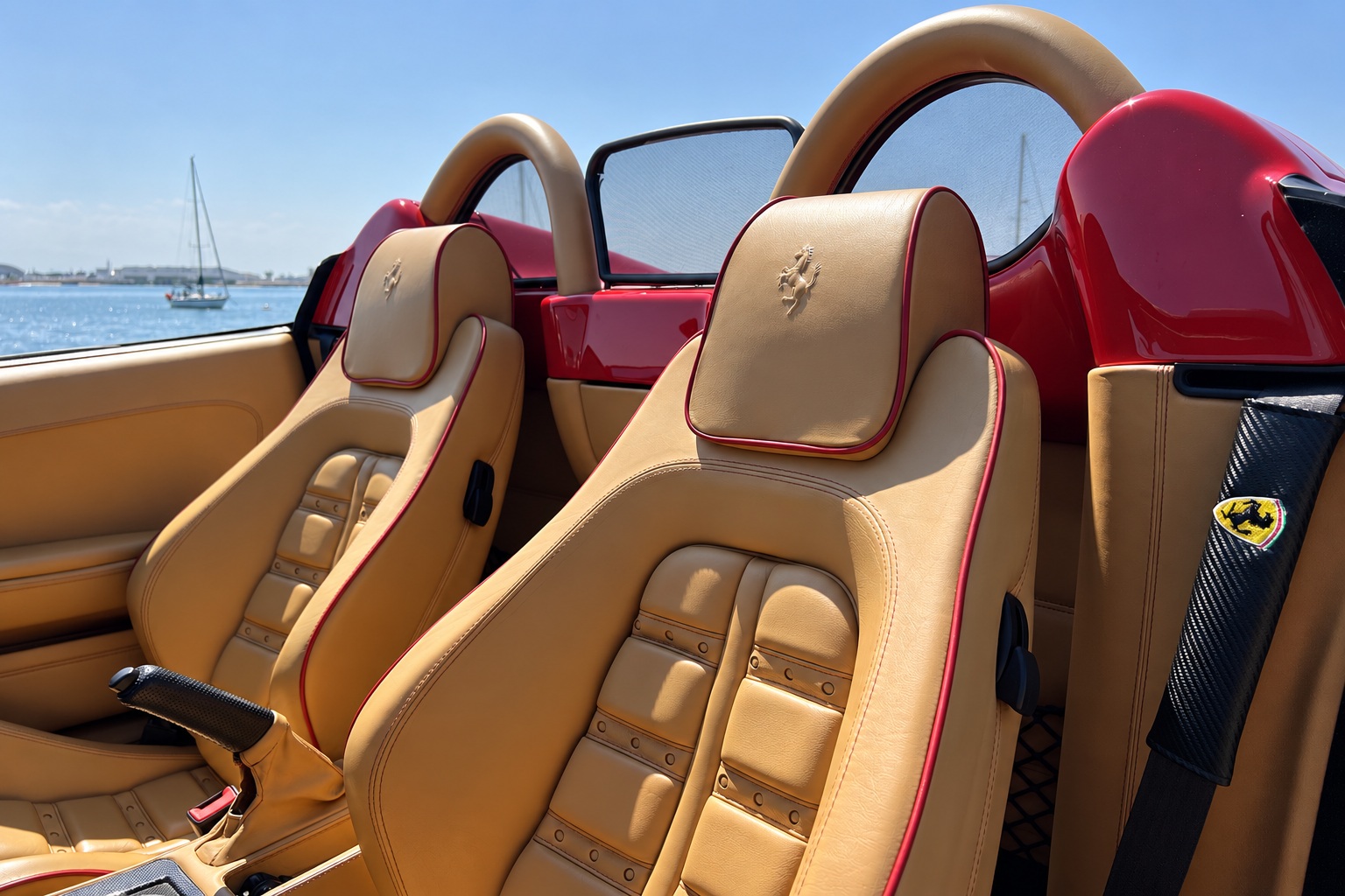 Tan leather seats with red piping and the prancing horse on the headrests in the red Ferrari F430 Spider