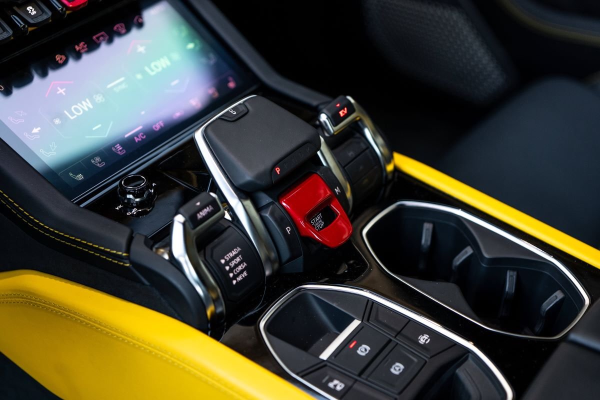 Centre console of the Urus SE, lower screen, red start flap, drive mode levers and yellow leather sides