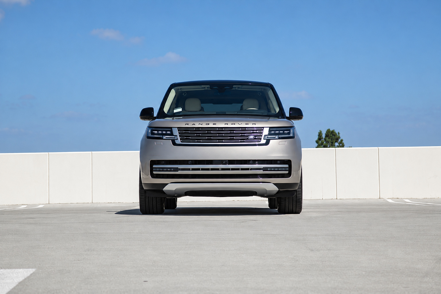 Head-on view of the champagne Range Rover HSE showing the grille, hood lettering and the black roof