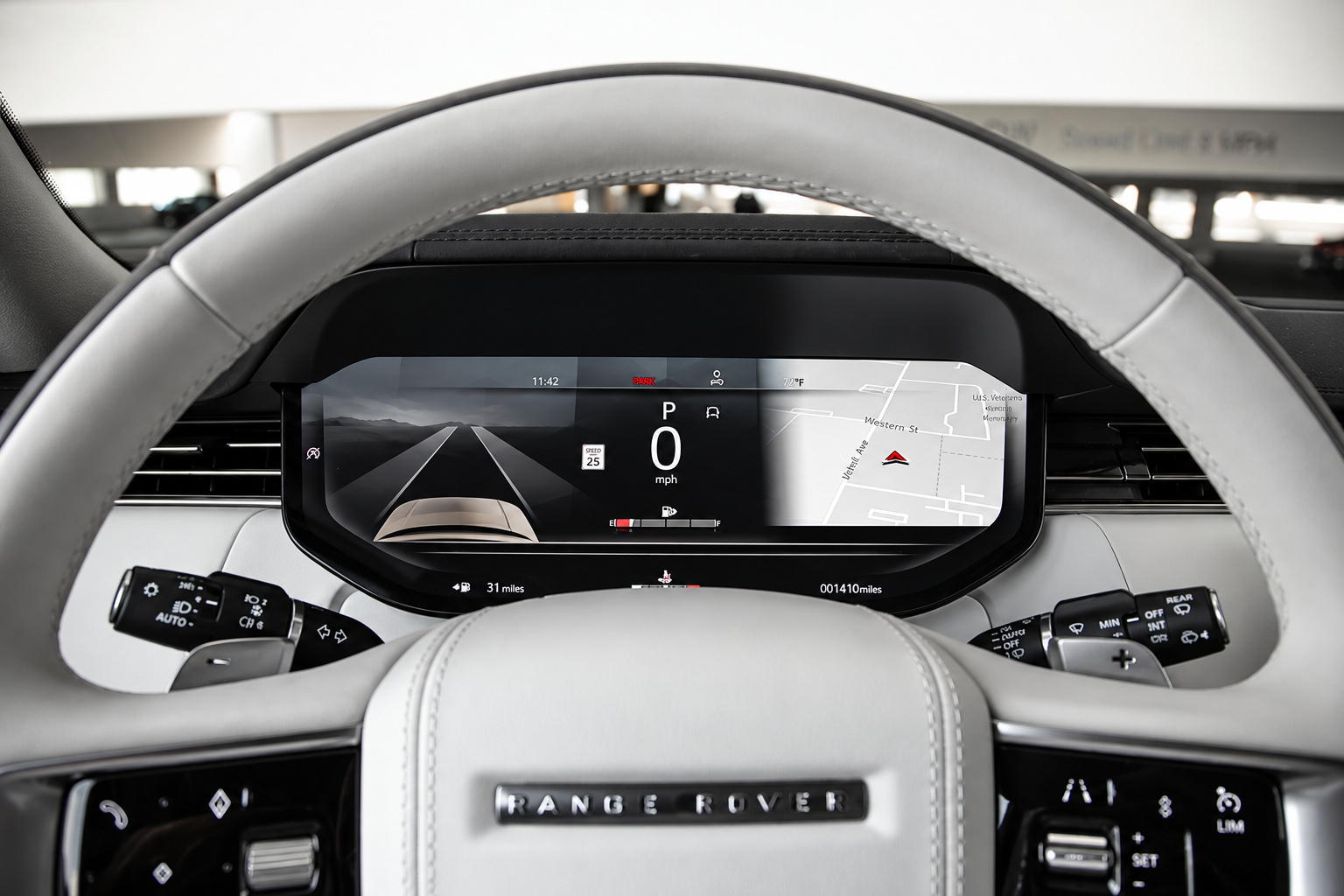 Ivory steering wheel of the Range Rover HSE with Range Rover lettering and the digital cluster behind
