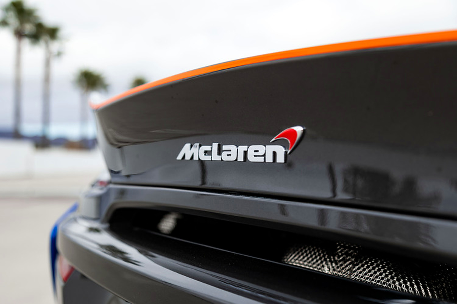 Close view of the 570S Spider rear wing with the orange edge and the McLaren badge
