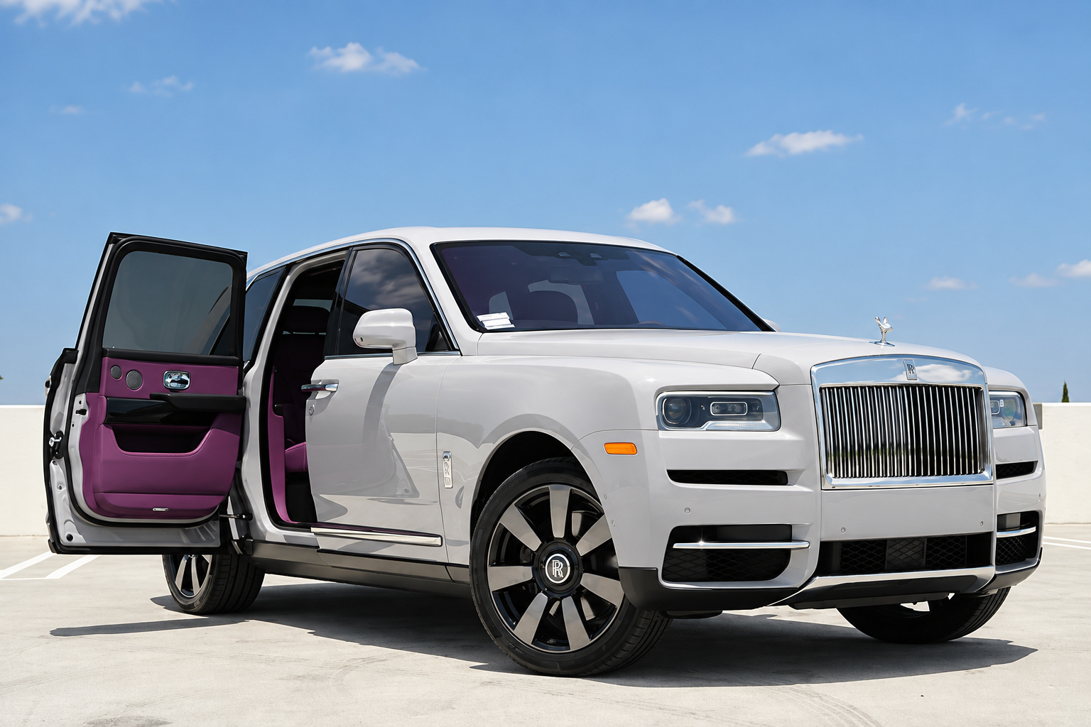 White Rolls Royce Cullinan on a rooftop deck in Los Angeles with the front coach door open on a purple leather cabin