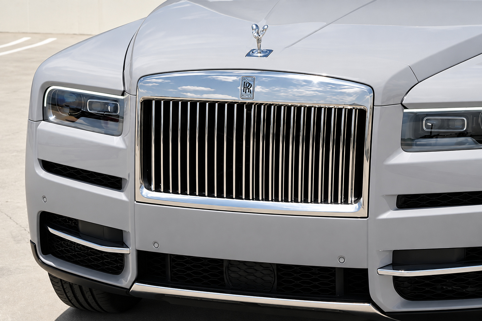 Close-up of the Cullinan chrome grille and Spirit of Ecstasy on the white hood