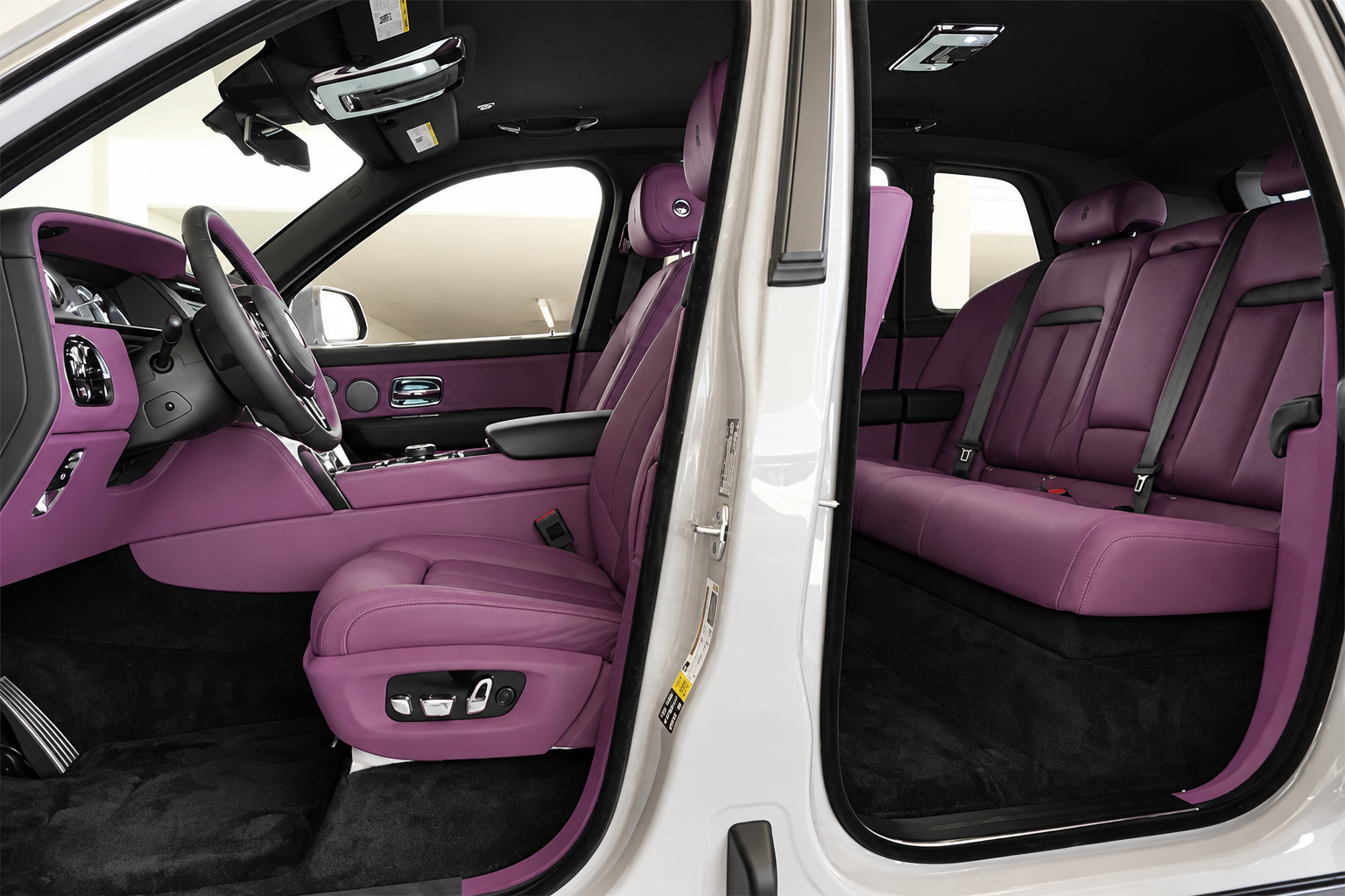 Looking across the front cabin of the white Cullinan, purple leather seats, black dash top and lambswool mats