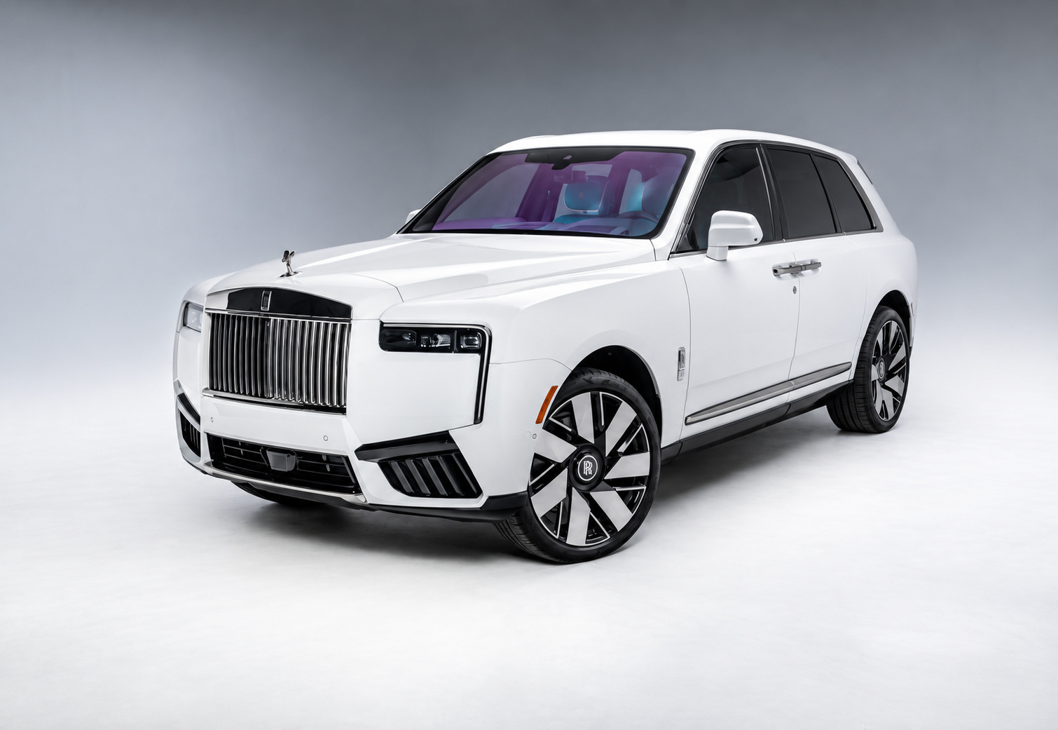 White Rolls Royce Cullinan Series II front three-quarter view in a studio, dark grille surround and two-tone wheels