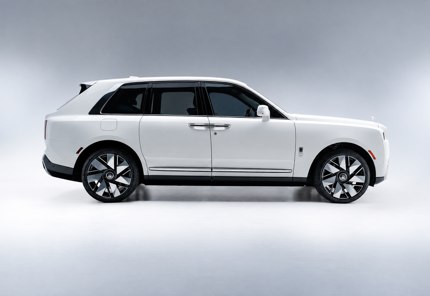 Side profile of the white Rolls Royce Cullinan Series II on two-tone wheels against a white studio backdrop