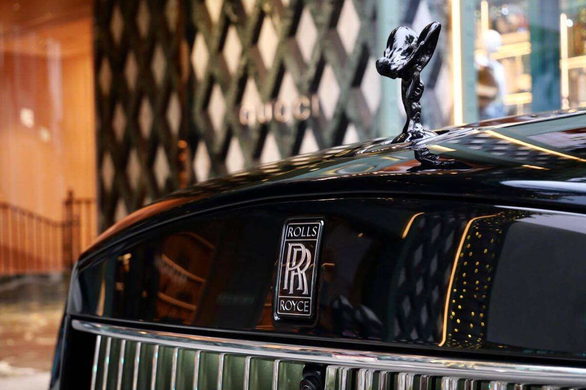 Darkened Spirit of Ecstasy and RR badge on the black hood of the Cullinan Black Badge Series II, Rodeo Drive behind
