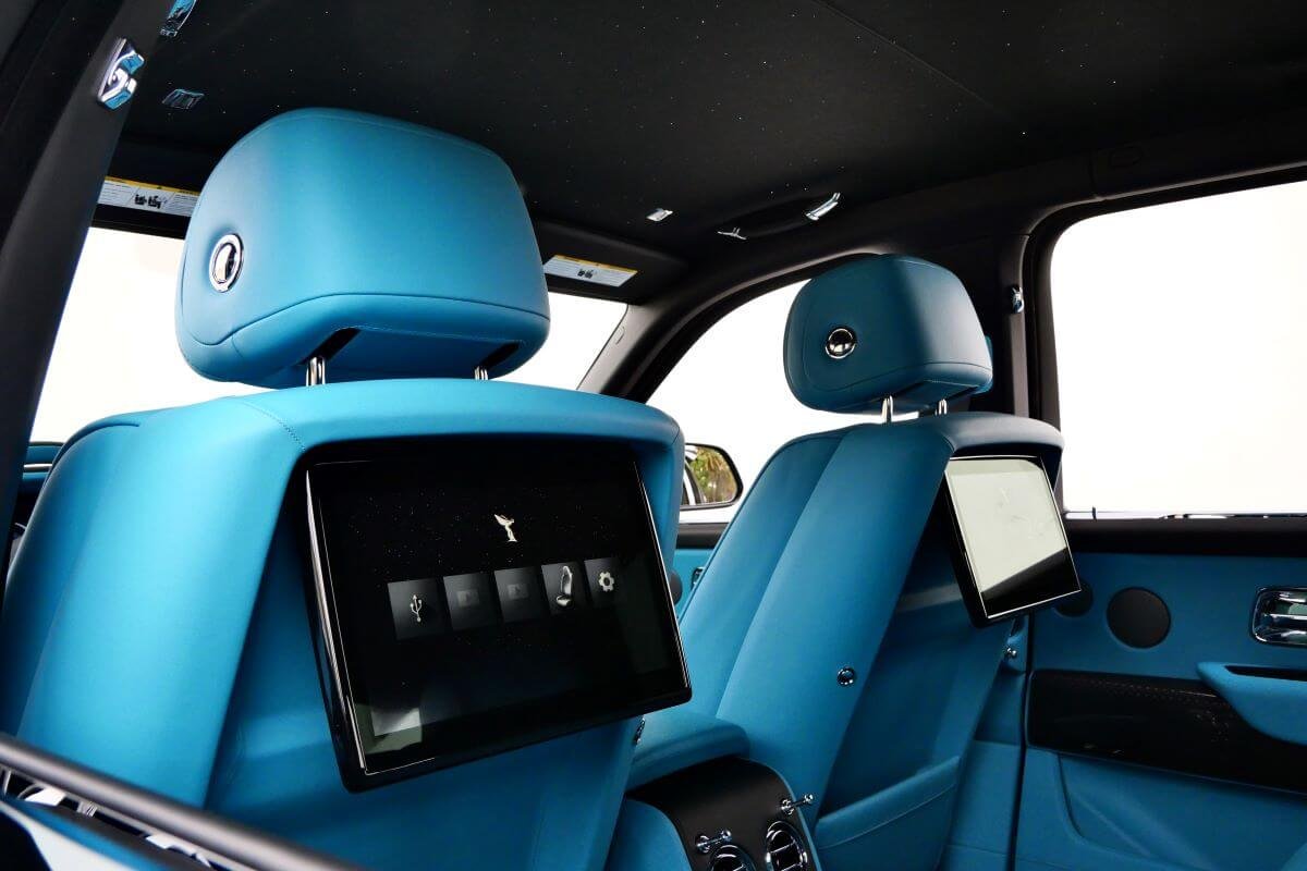 Rear seat entertainment screen folded out from the turquoise seatback in the Black Badge Cullinan