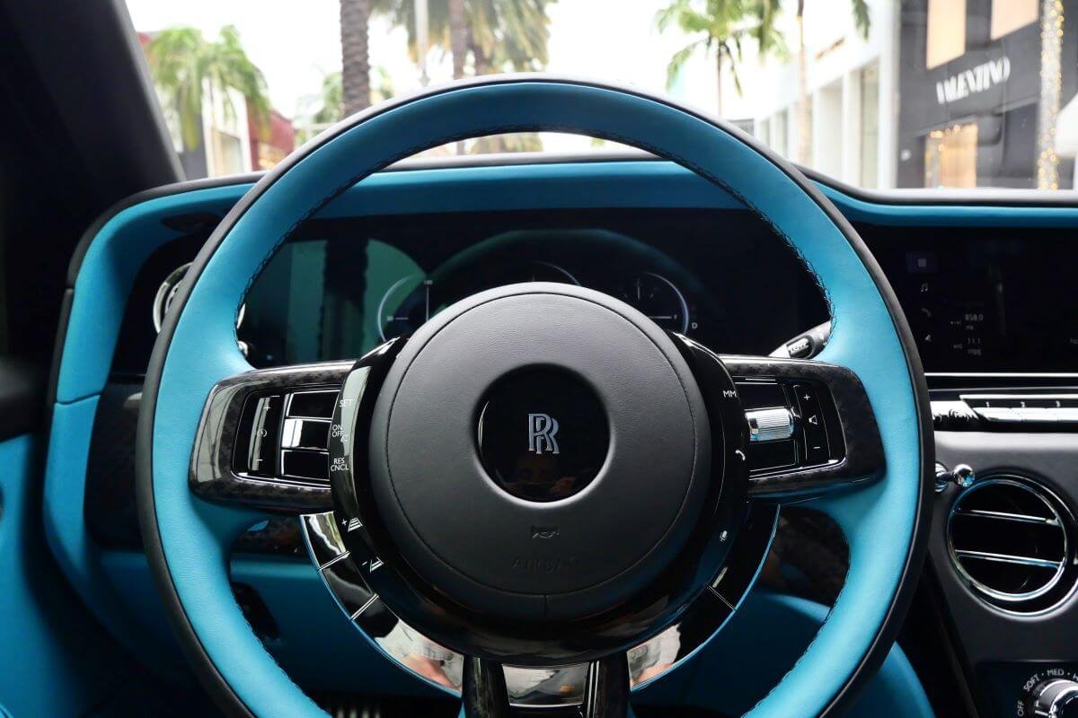 Close-up of the turquoise and black steering wheel with the RR center in the Cullinan Black Badge Series II