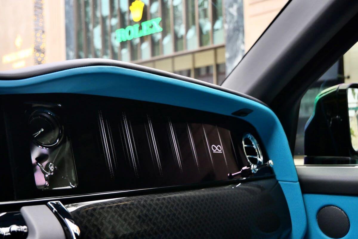 Front door panel of the Black Badge Cullinan, turquoise leather over black carbon fibre with a chrome speaker grille