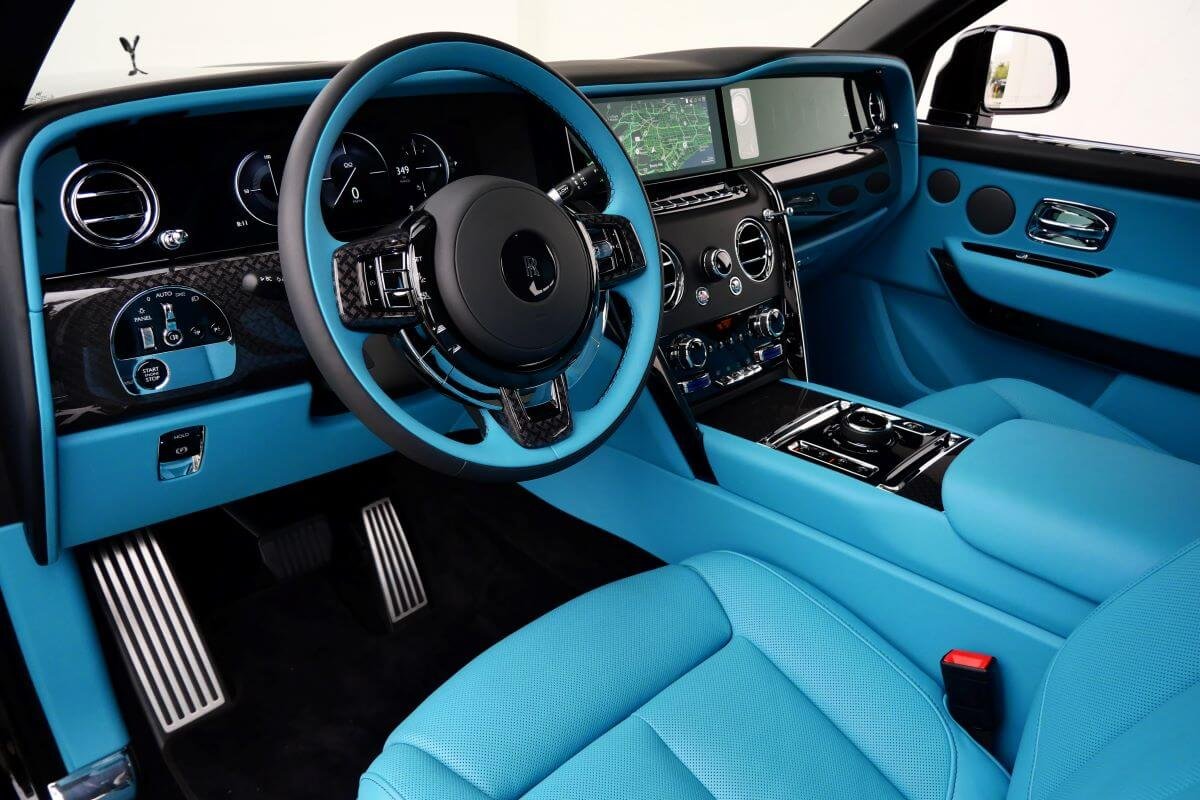 Driver's view of the turquoise dash, black steering wheel and gauge display in the Cullinan Black Badge Series II