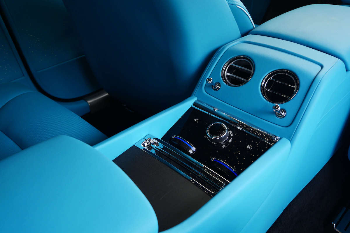 Rear seats and center console of the Rolls Royce Spectre in turquoise leather with chrome vents
