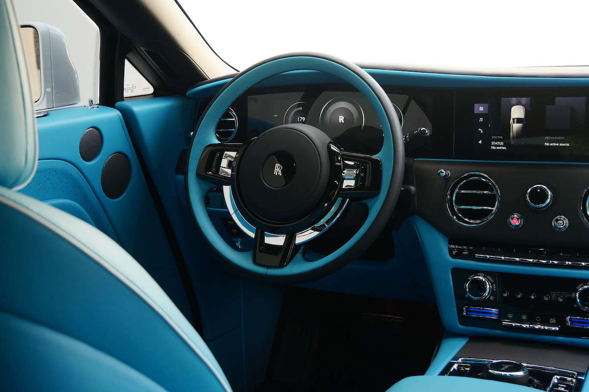 Turquoise steering wheel and dash of the Spectre with the digital gauges and the center screen