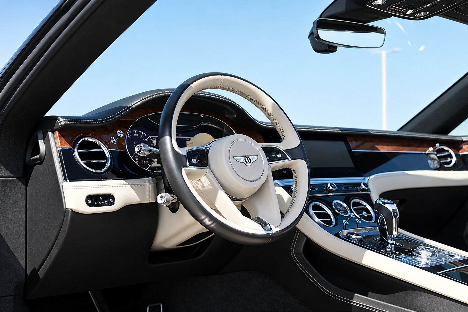 Bentley Continental GTC dash with the ivory steering wheel, open-pore wood and the rotating display screen