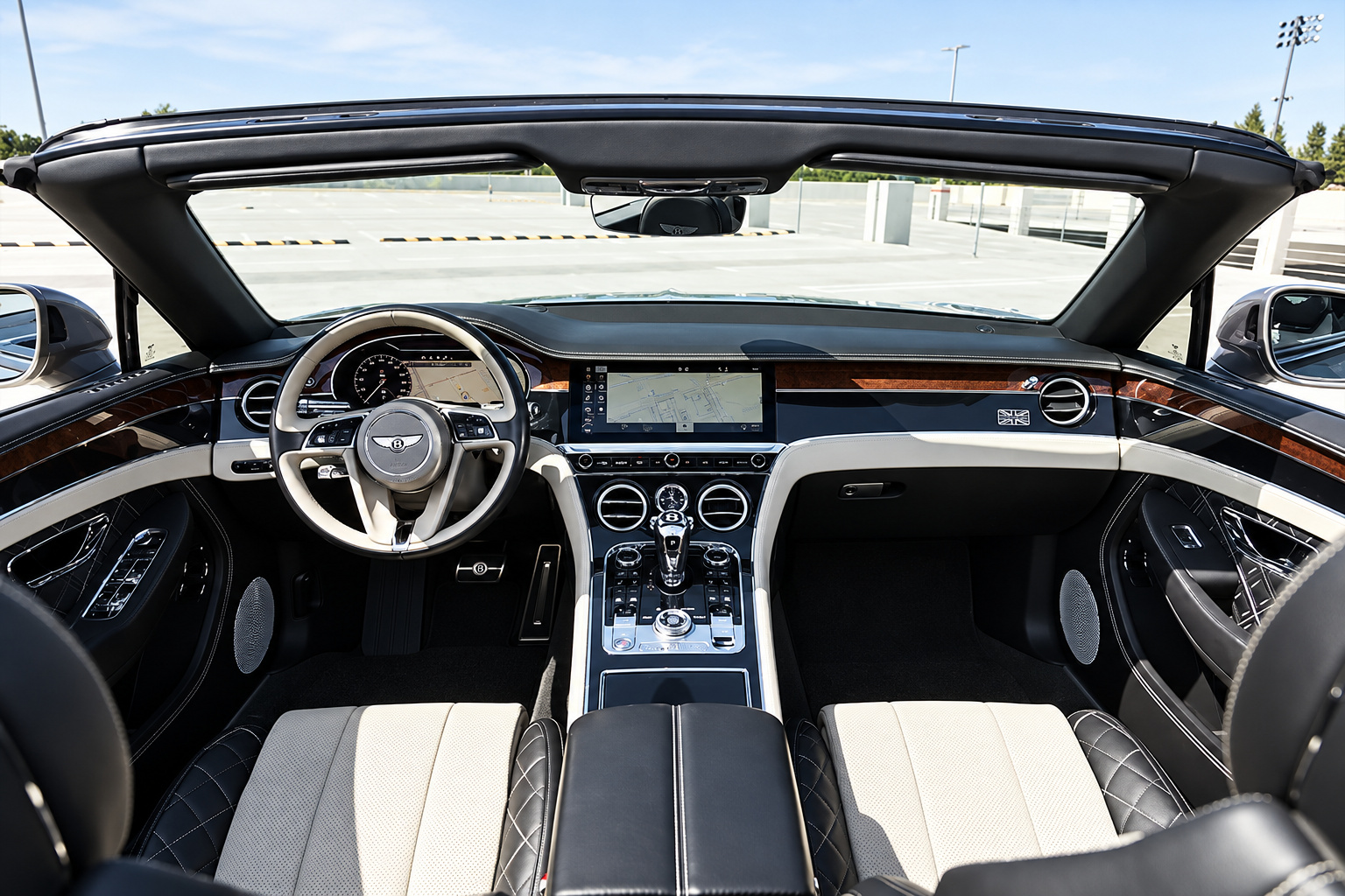 Looking down into the open Continental GTC cabin, two-tone black and ivory seats and the wood dash