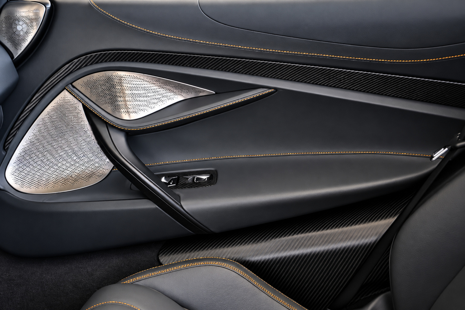 Carbon fibre door insert and orange stitching inside the grey McLaren 720S Spider, door pull and window switches