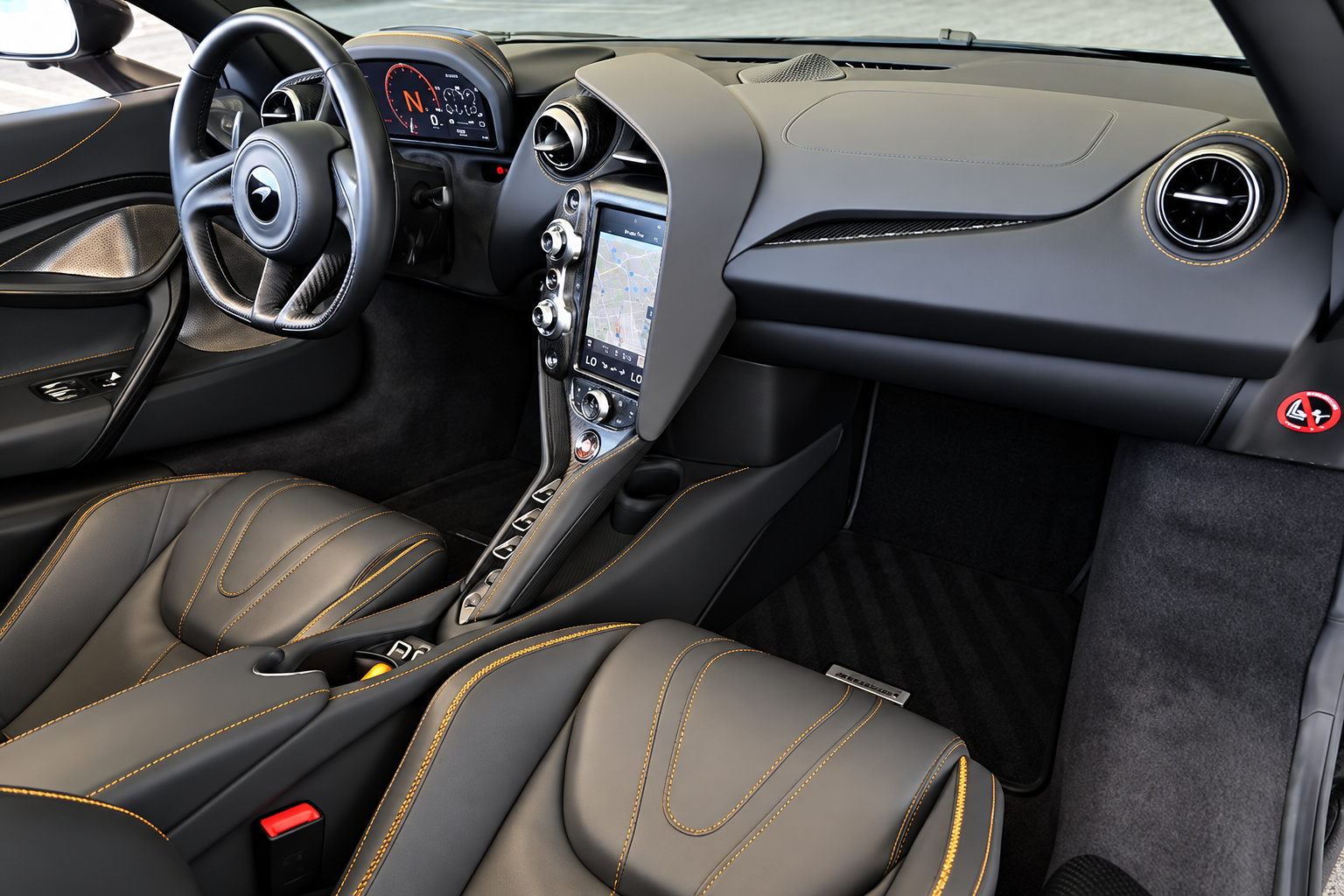 Cabin of the grey 720S Spider from the passenger side, driver display, portrait screen and orange-stitched seats