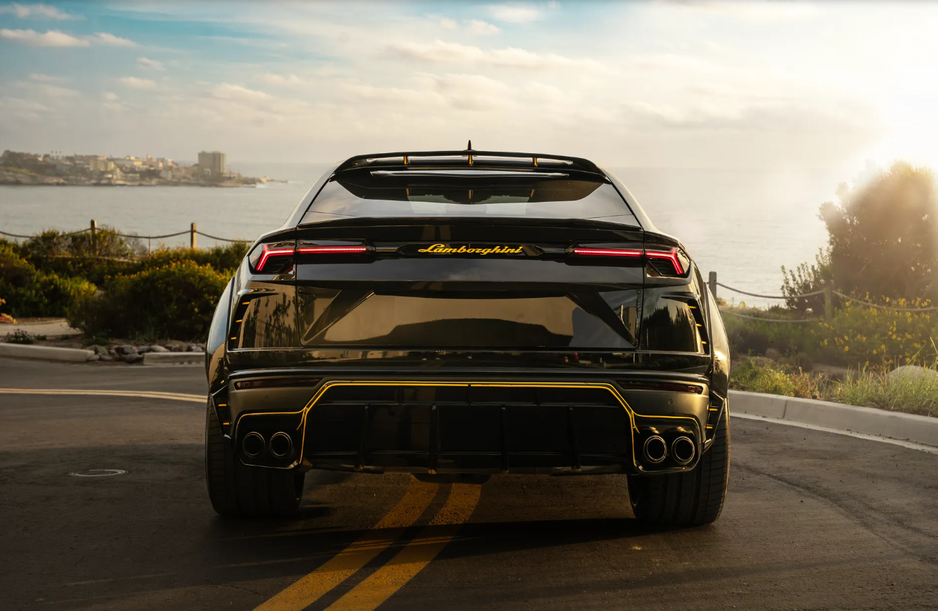 Rear view of the black Urus Widebody with yellow Lamborghini script and a yellow pinstripe around the diffuser