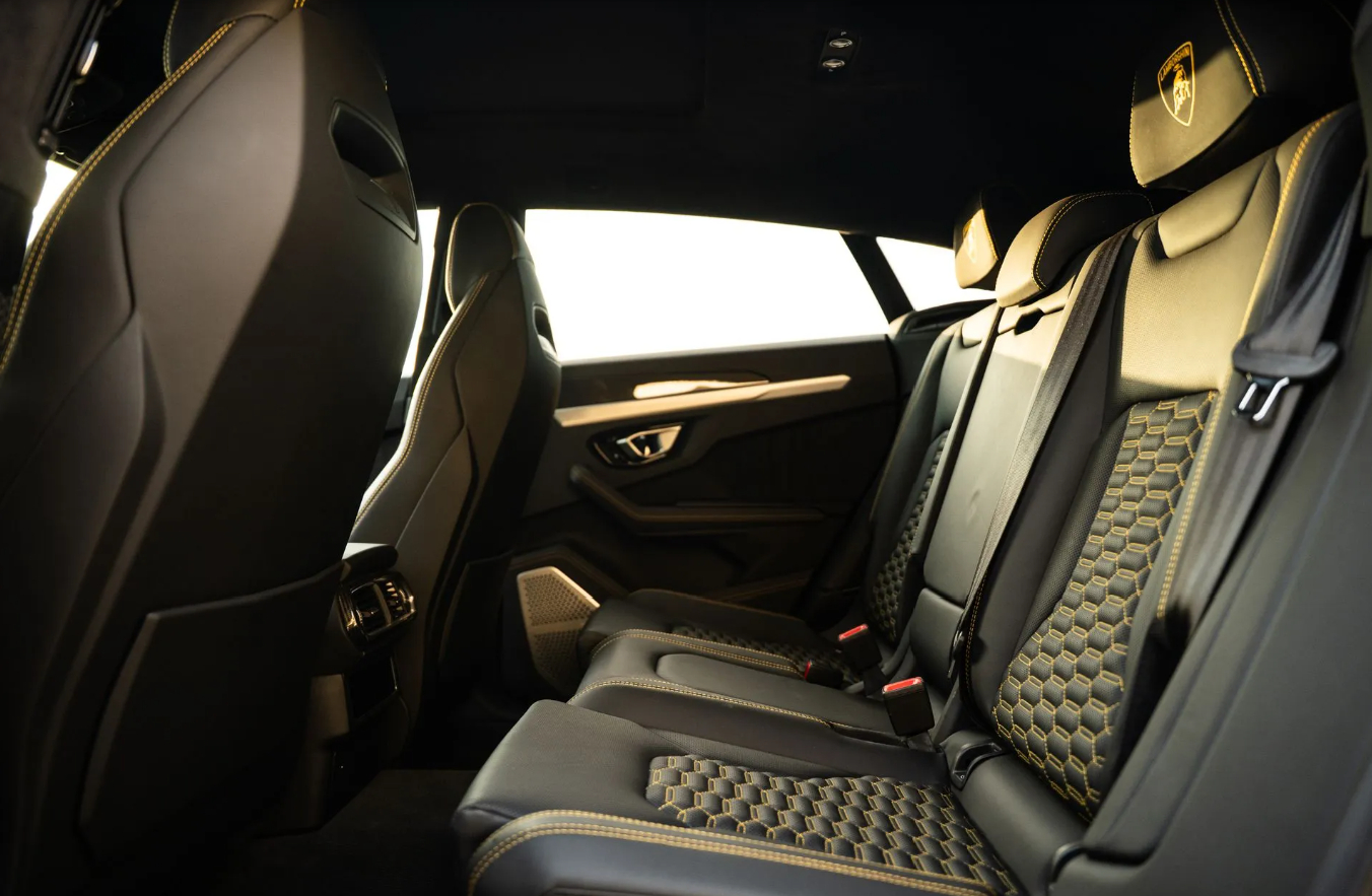 Rear seats of the Lamborghini Urus Widebody in black leather with yellow hexagon quilting and yellow shields