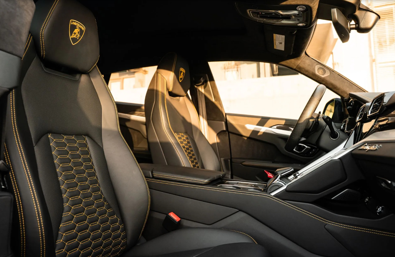 Front seats of the black Urus Widebody, yellow hexagon quilting and the Lamborghini shield in yellow on the headrests