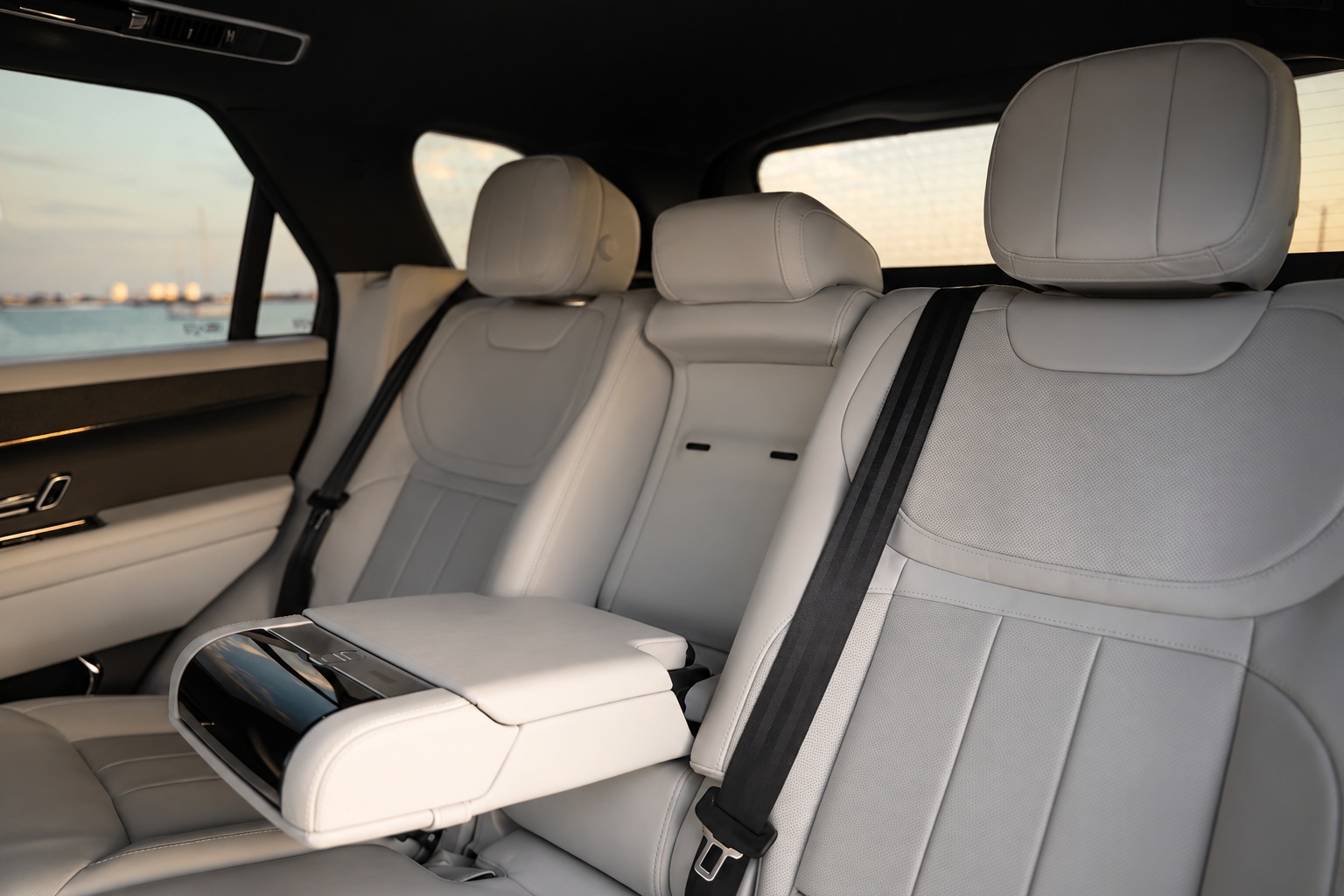Light grey leather rear bench of the Range Rover Sport with the center armrest folded down