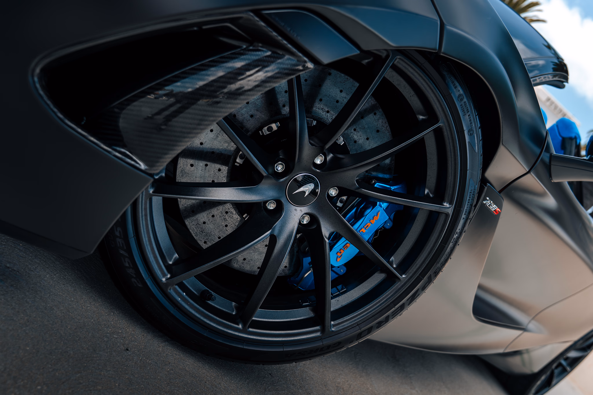 Close view of the 720S Spider's black multi-spoke wheel, blue brake caliper and carbon ceramic disc